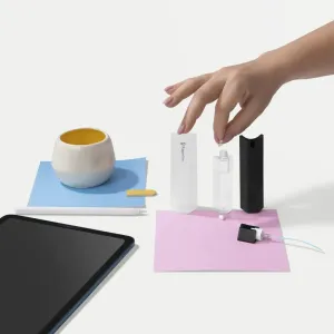 Komponentene i Paperlike Cleaning Kit v2 arrangert på en hvit flate med et synlig hjørne av et nettbrett