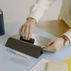 Paperlike Cleaning Kit v2 brukes til å rengjøre en nettbrettskjerm, med rengjøringstilbehør på en bordplate
