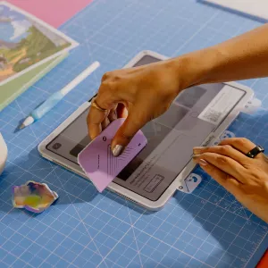 Paperlike 3 skärmskydd appliceras på en iPad med justeringskort på en blå skärmatta