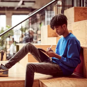 Person som använder en iPad Mini med Apple Pencil och visar Paperlike pappersliknande skärmskydd för teckning
