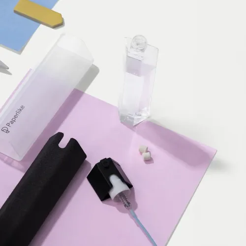 Valymo rinkinys su skaidriu dėklu, juodu mikropluošto dangteliu, atidarytu pripildymo buteliuku, purškimo galvute su žarna ir dviem granulėmis.